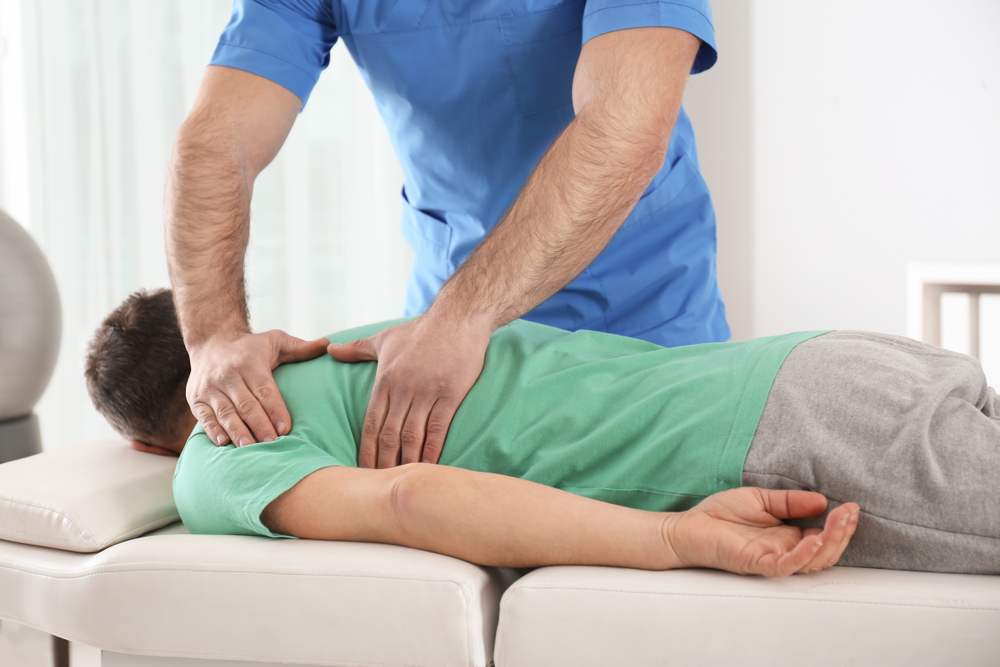 Spinal Adjustment Therapy Session - Physiotherapy A physiotherapist performs a spinal adjustment on a patient to improve mobility, posture, and reduce pain. - Physiotherapy