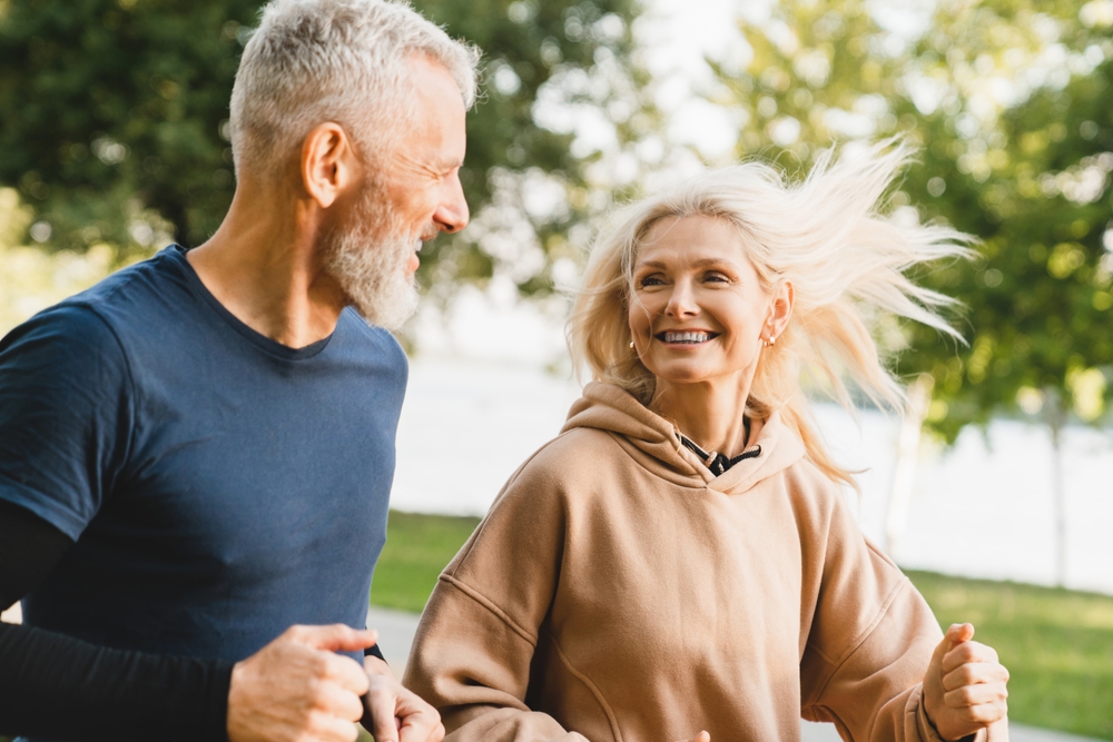 Active Senior Couple Jogging Outdoors - Chiropractic Adjustment A healthy senior couple enjoys jogging together, showcasing the benefits of chiropractic care for mobility and wellness. - Chiropractic Adjustment